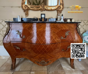 Antique bombe-style wooden vanity with intricate marquetry, bronze hardware, and black marble top.